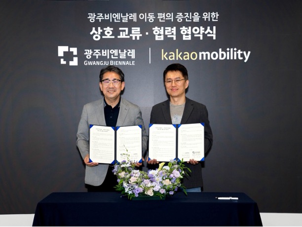 광주비엔날레 및 카카오모빌리티 관계자가 모여 협약식 기념 사진을 촬영하고 있습니다.