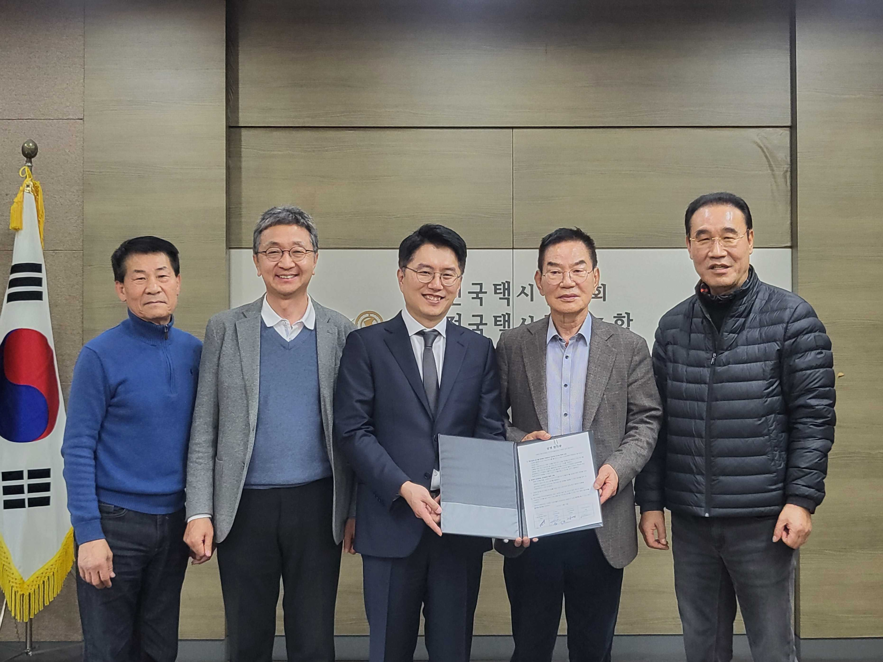 카카오모빌리티 대표와 택시업계 회장이 간담회를 마치고 기념 사진을 촬영하고 있습니다.