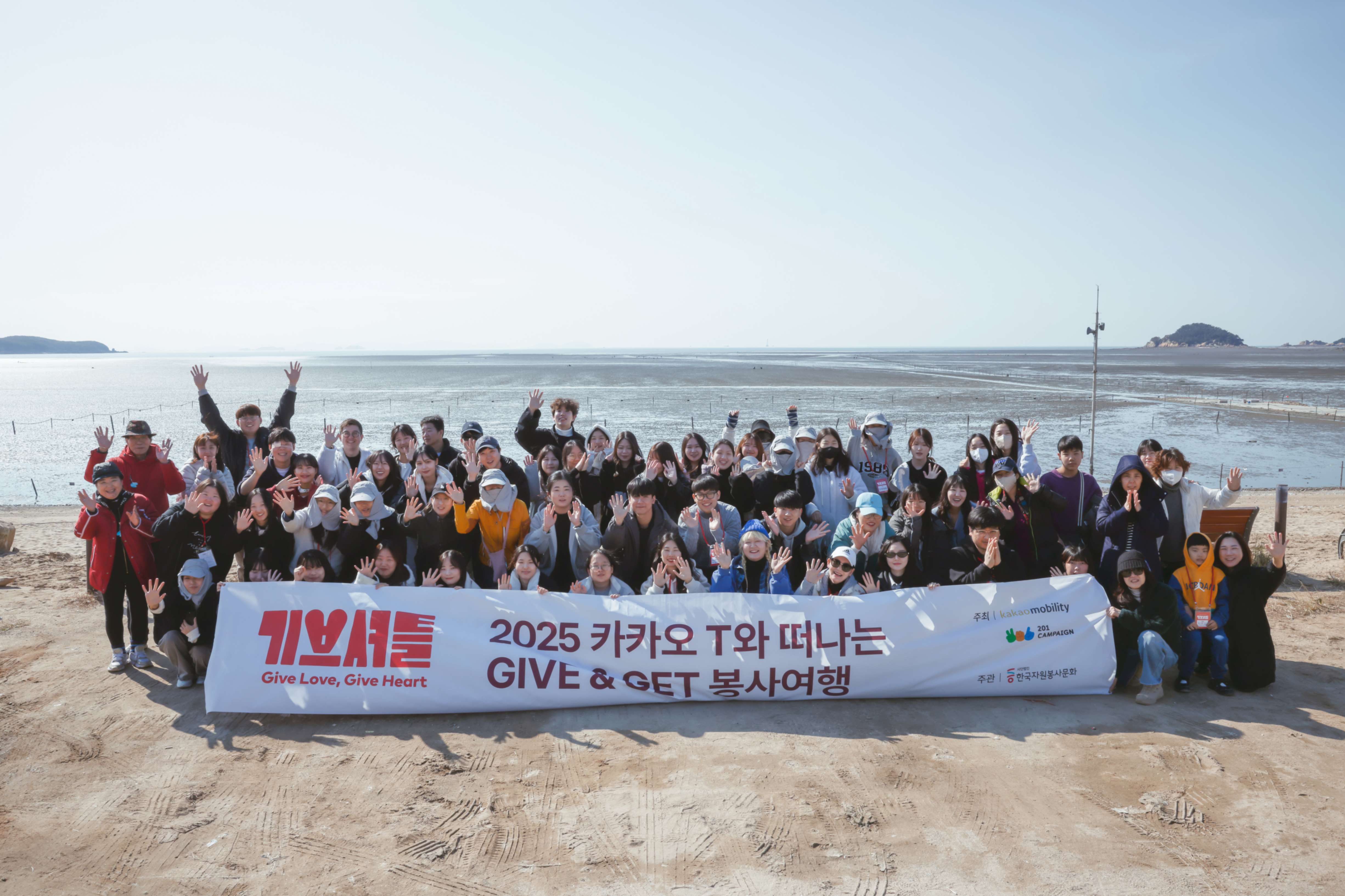 기버분들은 마시안 해변 앞에서 단체사진을 촬영하고 있습니다.